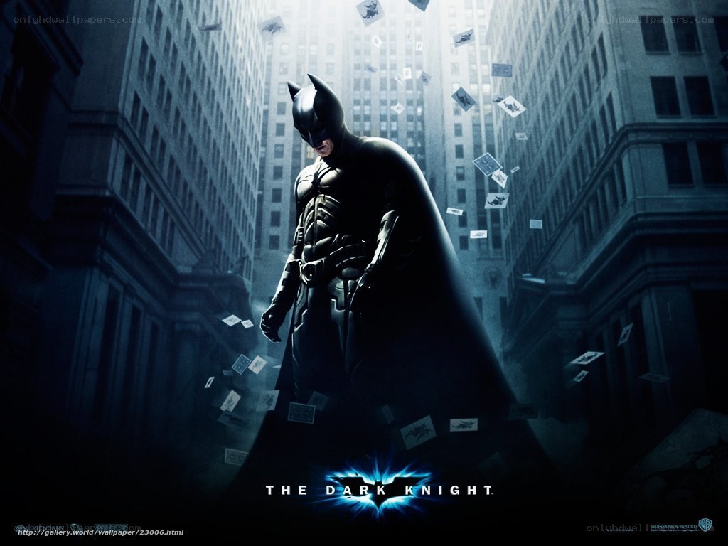 Batman stands in a city alley