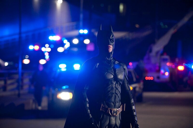 Batman stands in a city at night