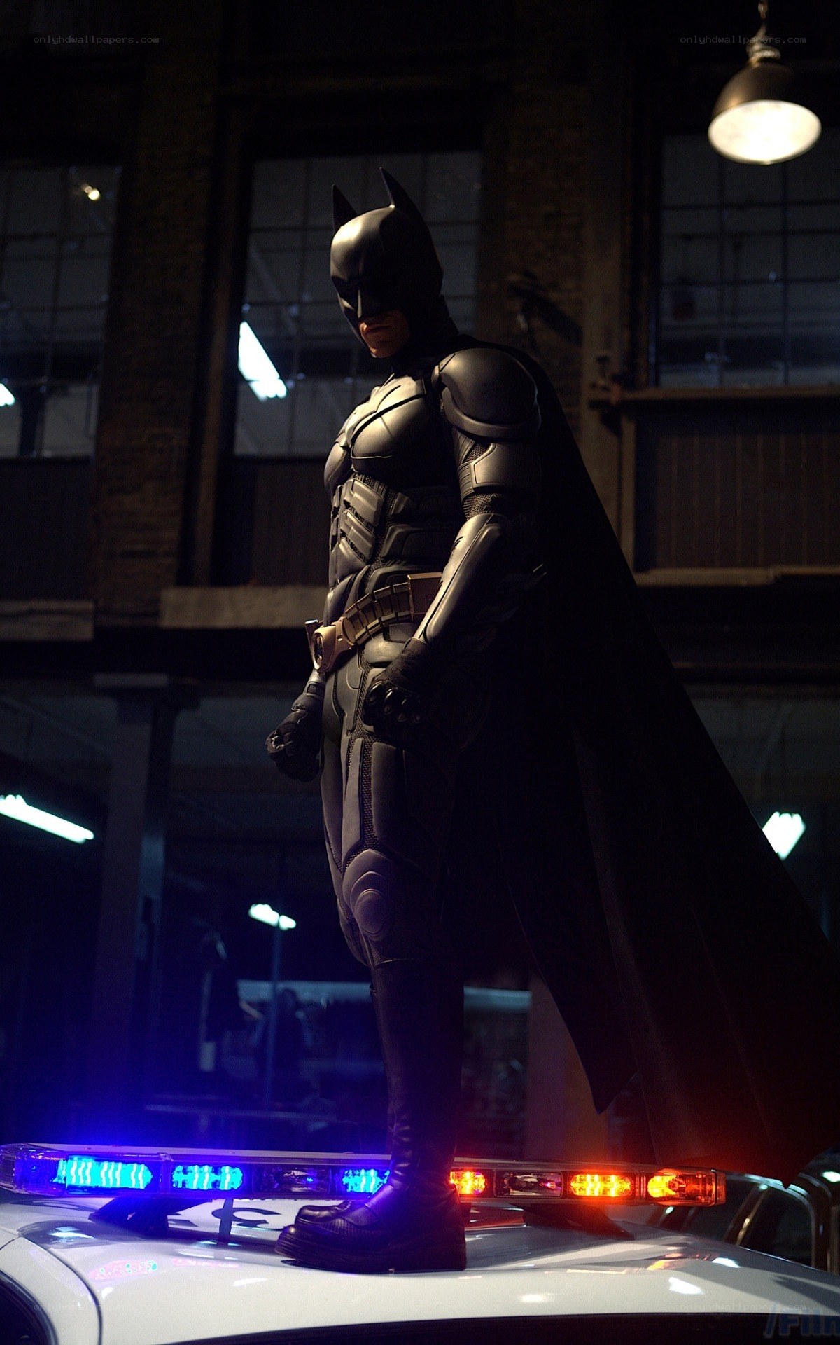 Batman stands on police car