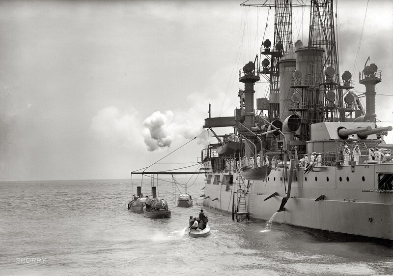 Battleship at sea with boats