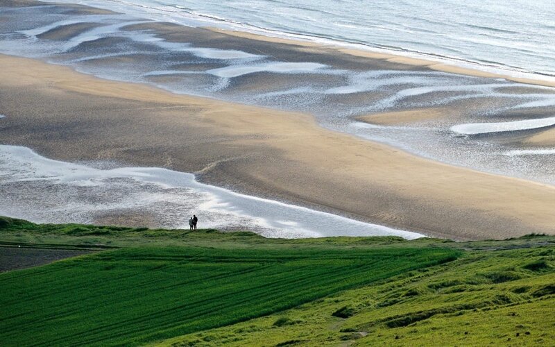 Beach and green fields landscape