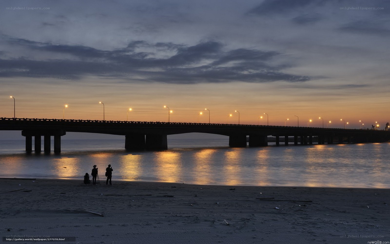 Beach at dusk with bridge