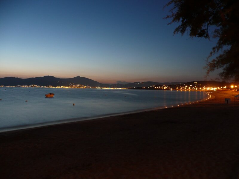 Beach at dusk with city lights