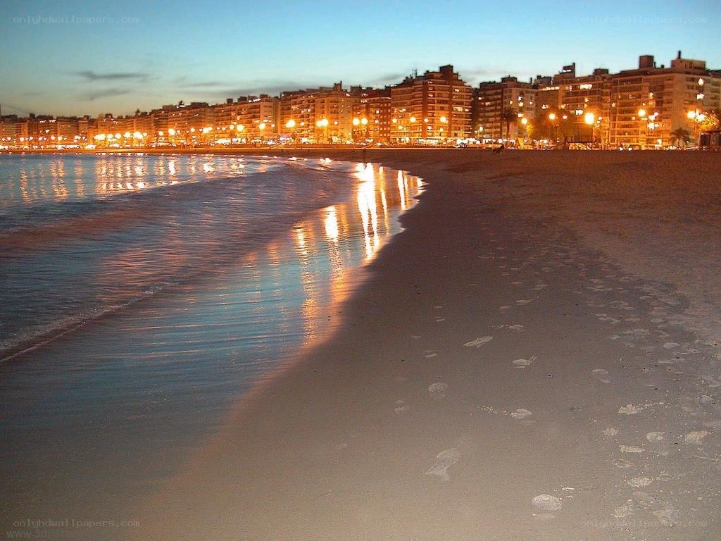 Beach at dusk with city lights