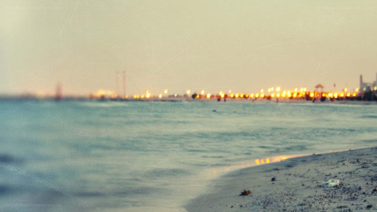 beach at dusk with city lights