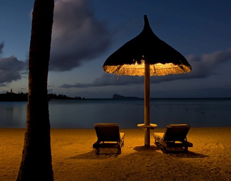 Beach at dusk with lounge chairs