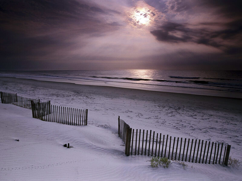 Beach at dusk with wooden fence
