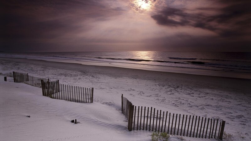 Beach at dusk with wooden fence