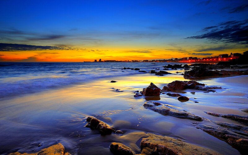 Beach at Sunset — Blue, Serene, Photograph, Rocks, Ocean, City Skyline