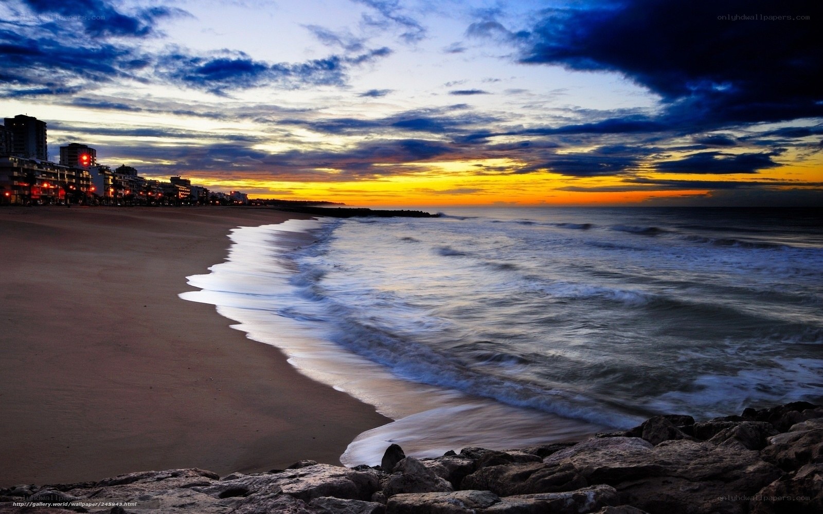 Beach at sunset with city lights