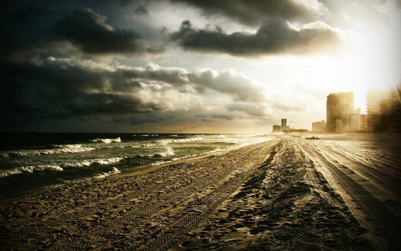 Beach at sunset with city skyline
