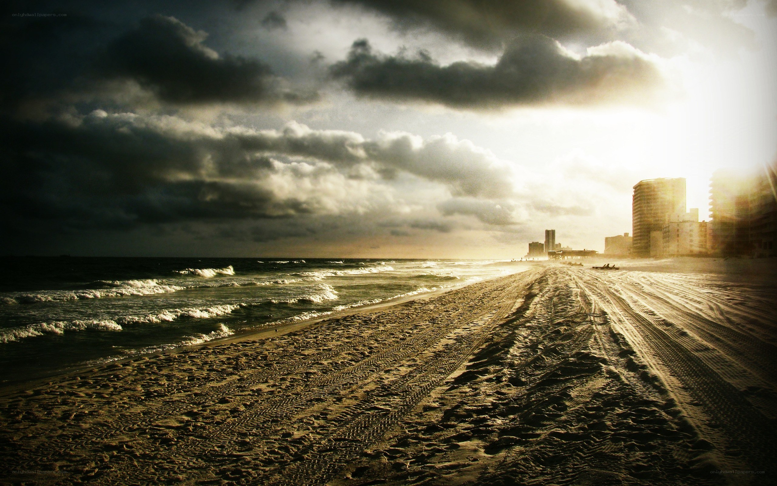 Beach at sunset with city skyline