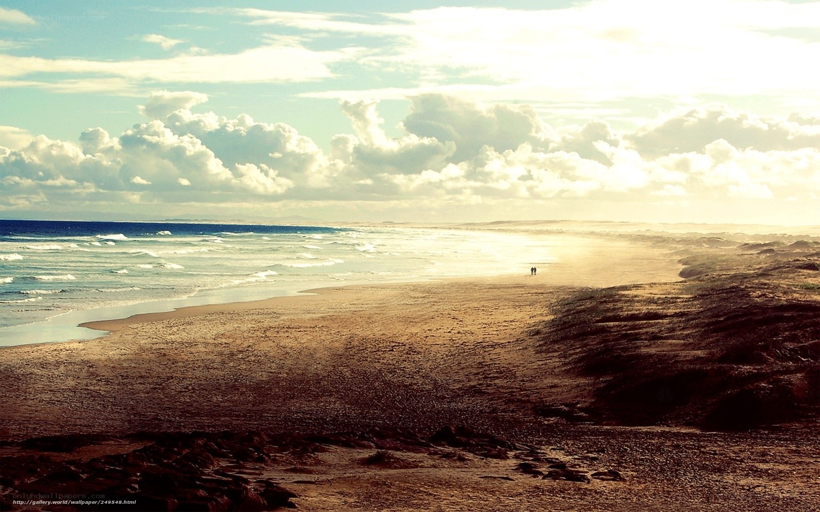 Beach at sunset with couple