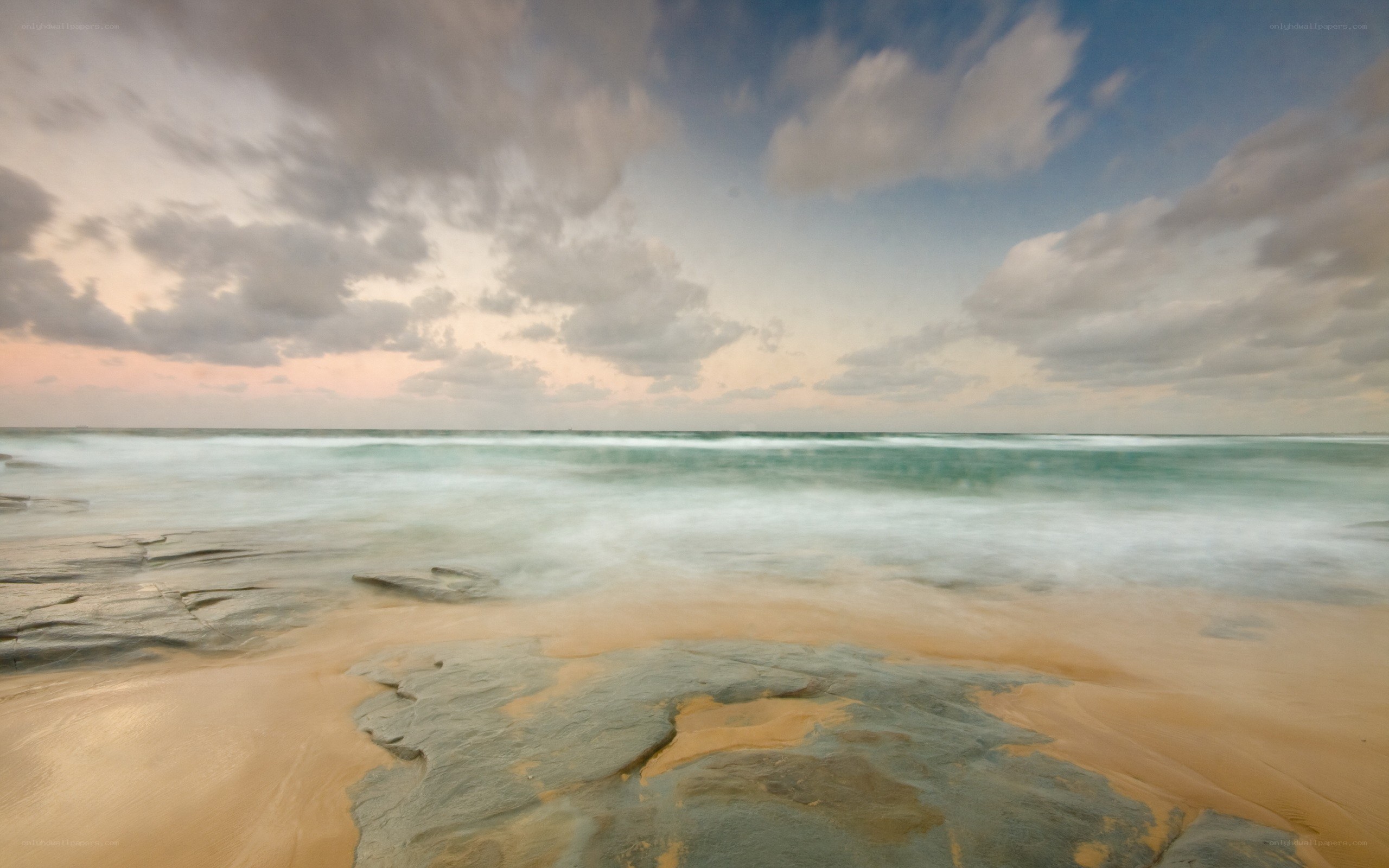 Beach at sunset with rocky shore