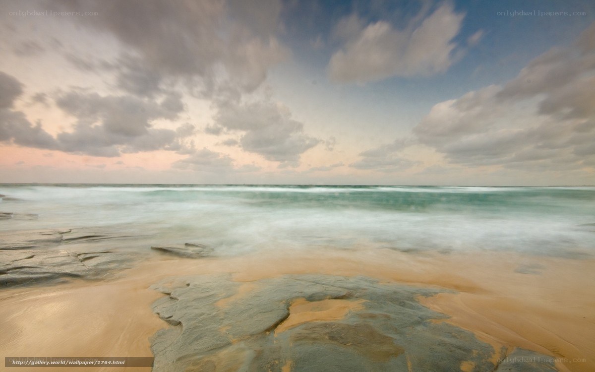 Beach at sunset with rocky shore
