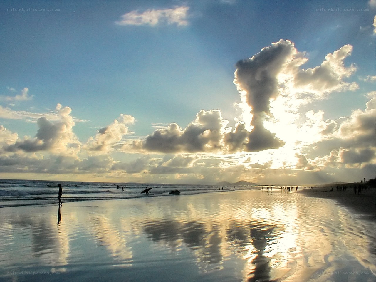 beach at sunset with surfers