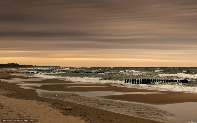 Beach at sunset with wooden groynes