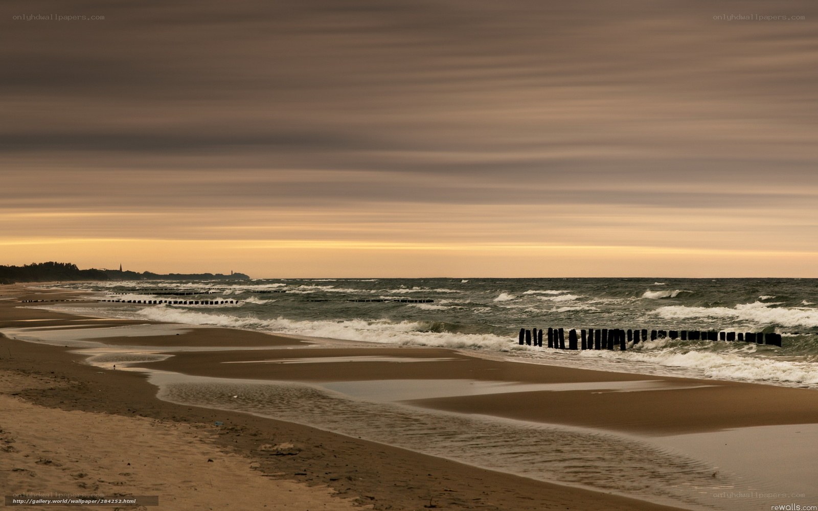 Beach at sunset with wooden groynes