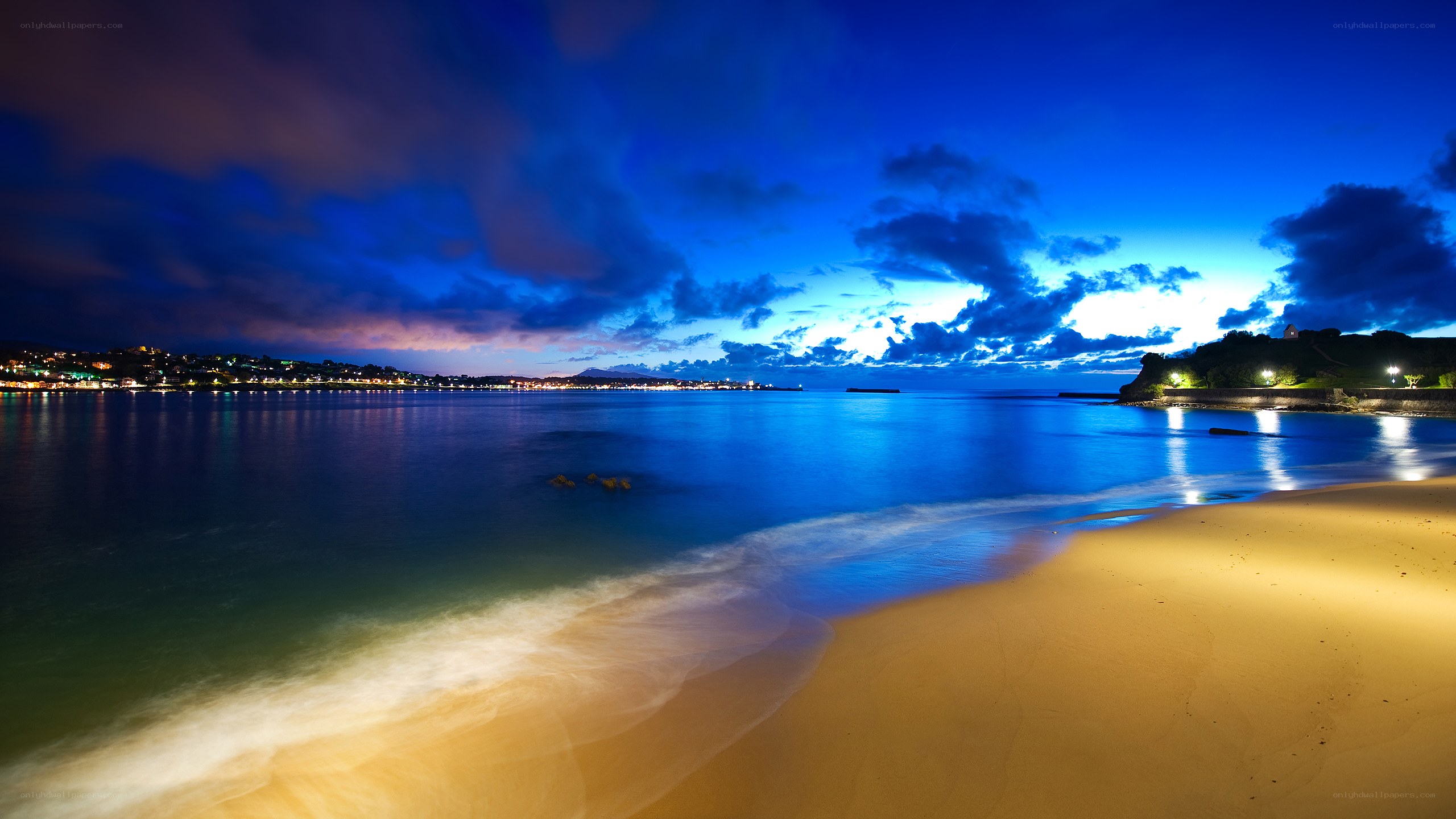 Beach at twilight with city lights