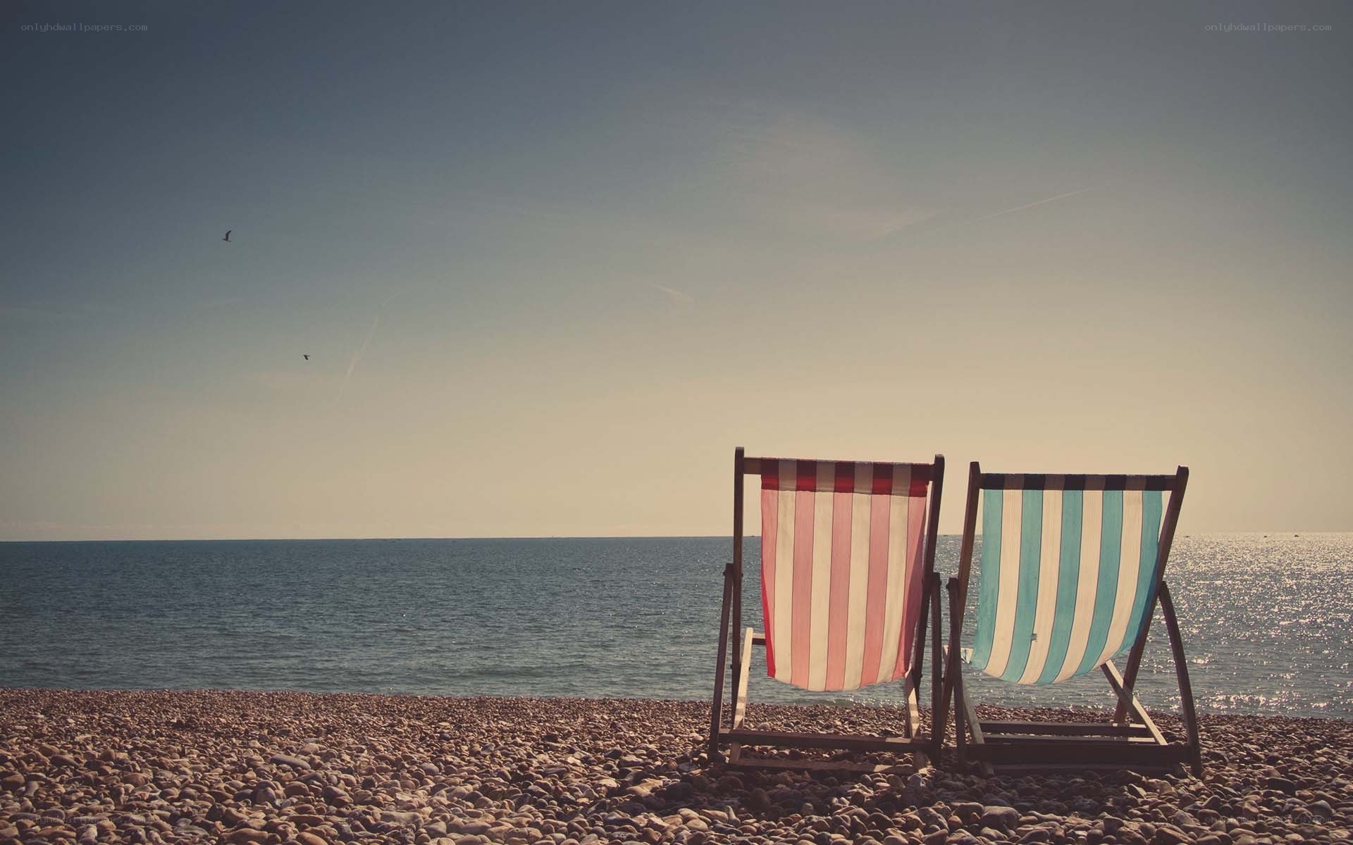 Beach chairs on a pebble shore