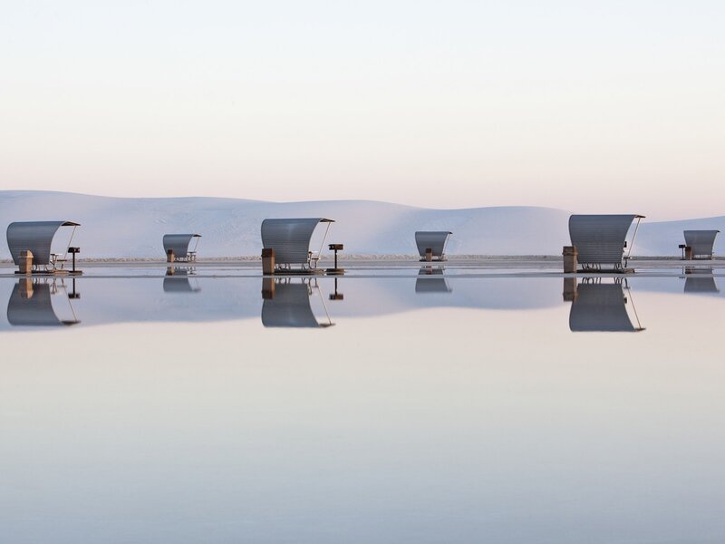 Beach chairs on a reflective surface