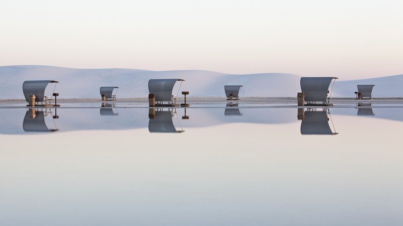 Beach chairs on reflective water