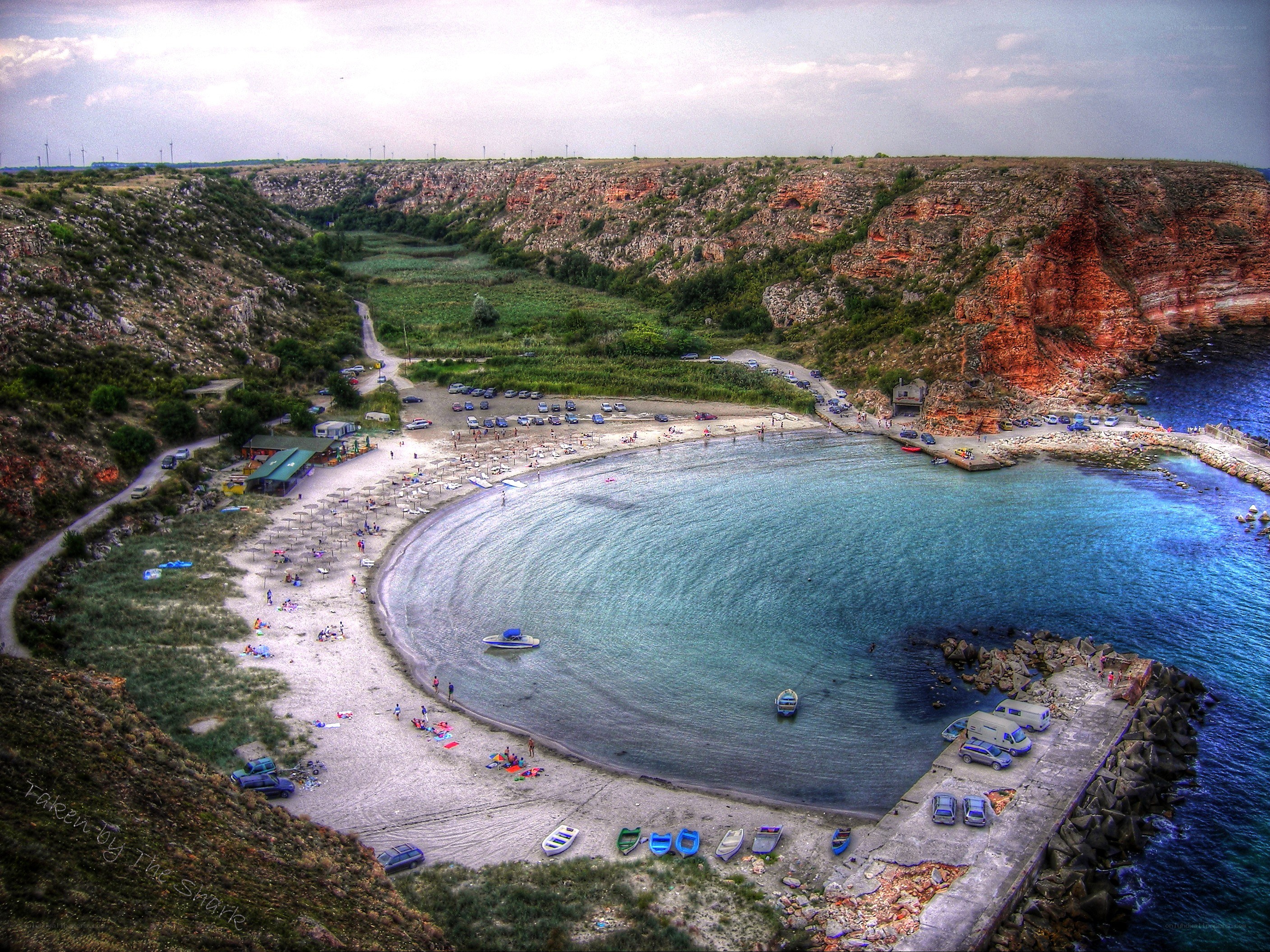 beach cove with boats and cliffs