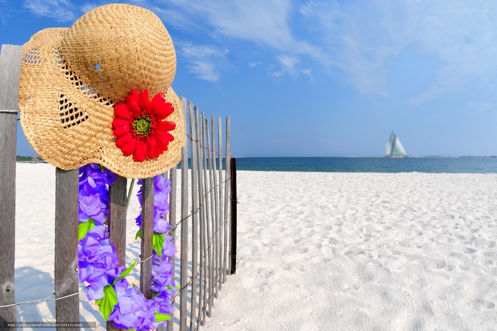 Beach hat with flowers on fence