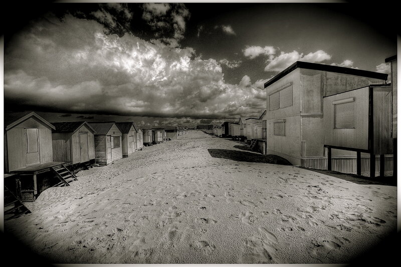 Beach huts under cloudy sky