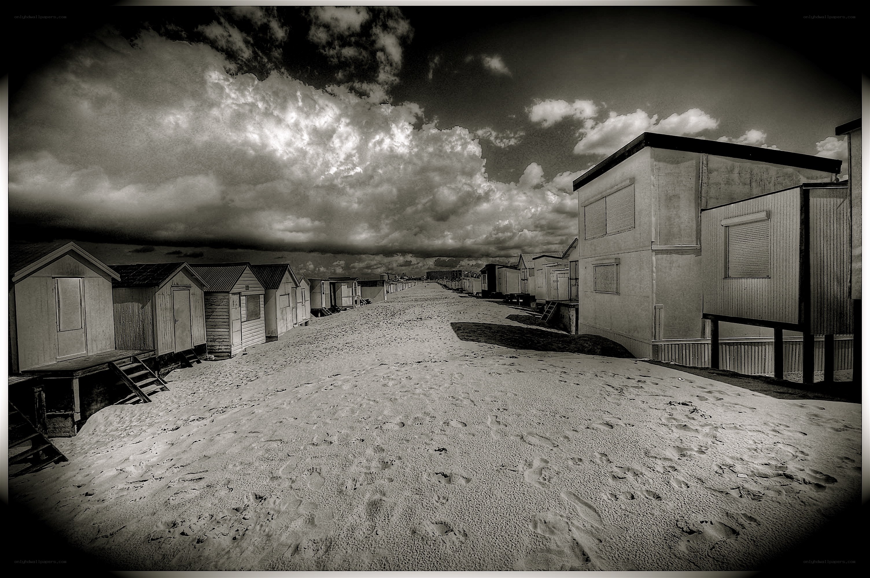 Beach huts under cloudy sky