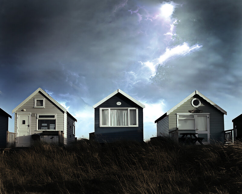 Beach huts under stormy sky