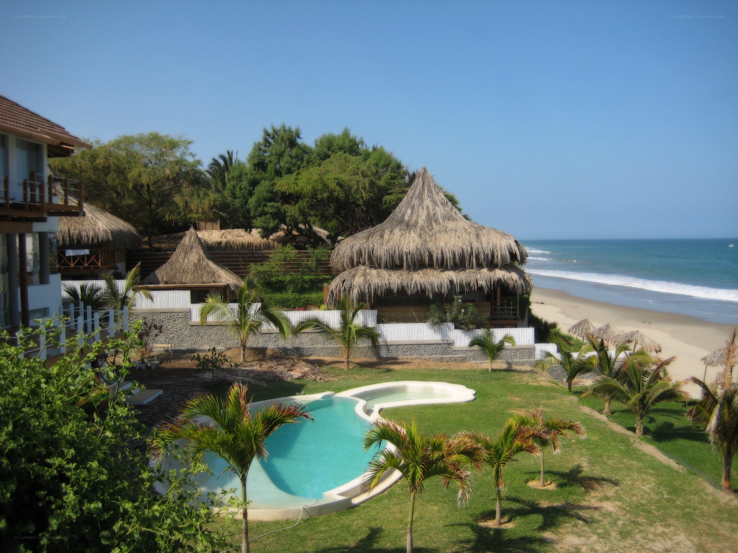 Beach resort with pool and thatched huts