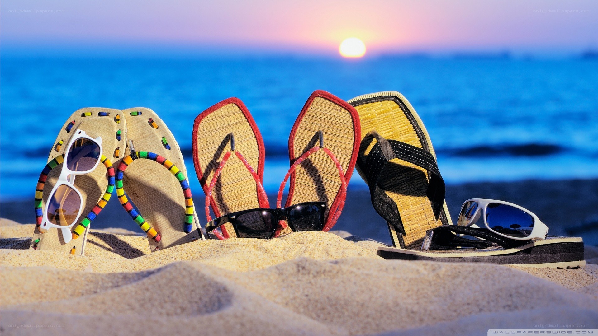 Beach sandals and sunglasses at sunset