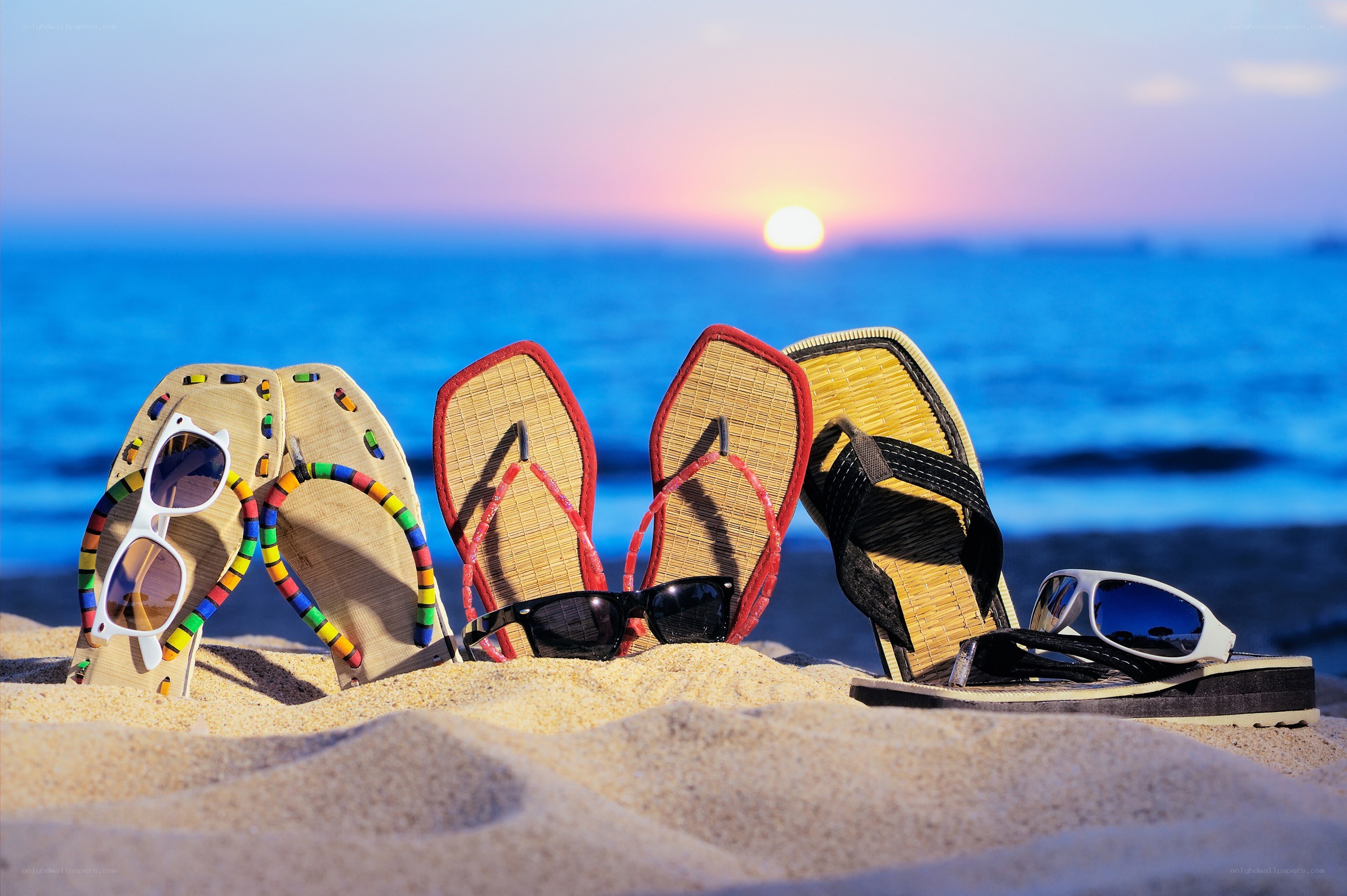 Beach sandals and sunglasses at sunset