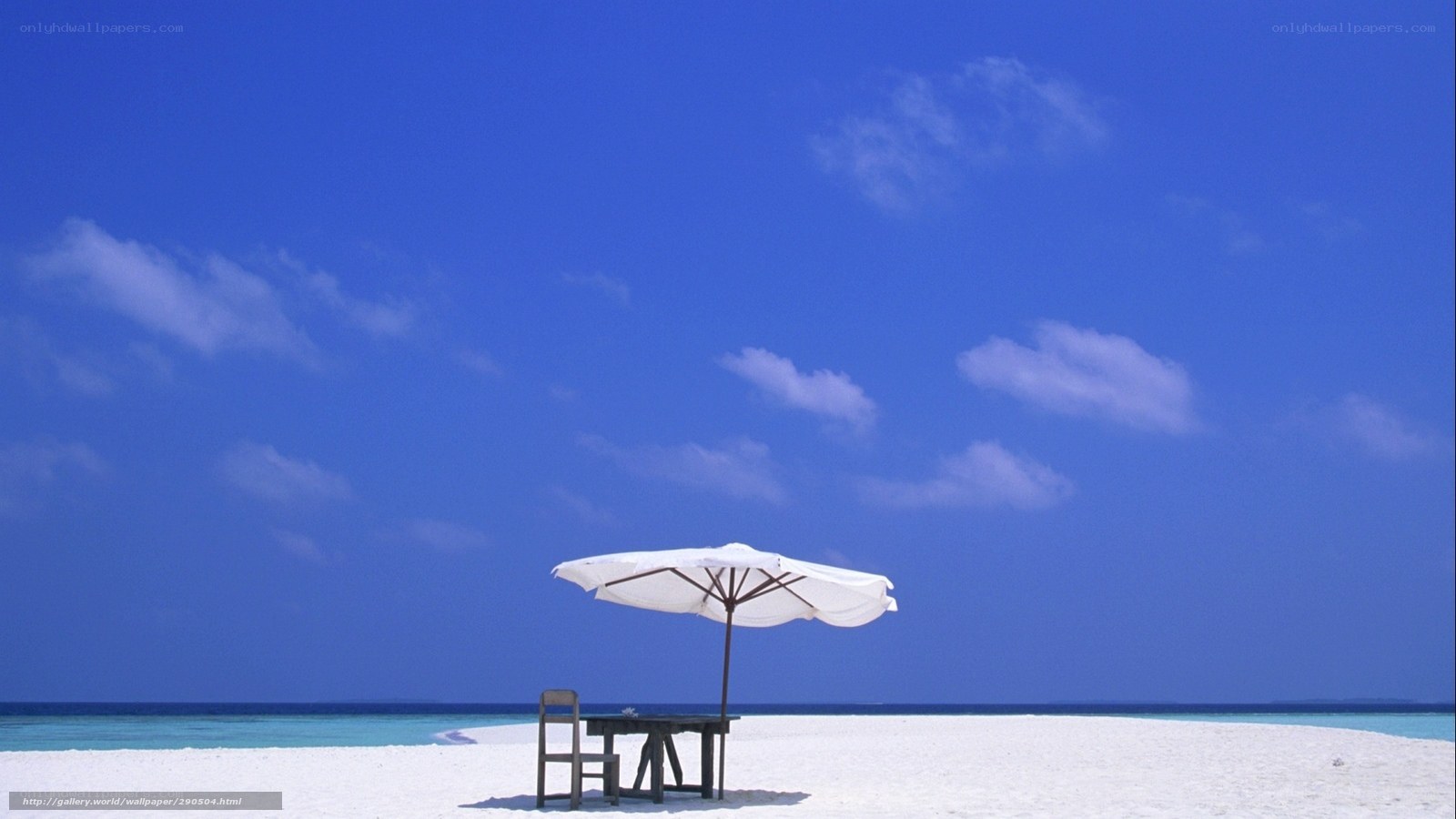 Beach table under white umbrella