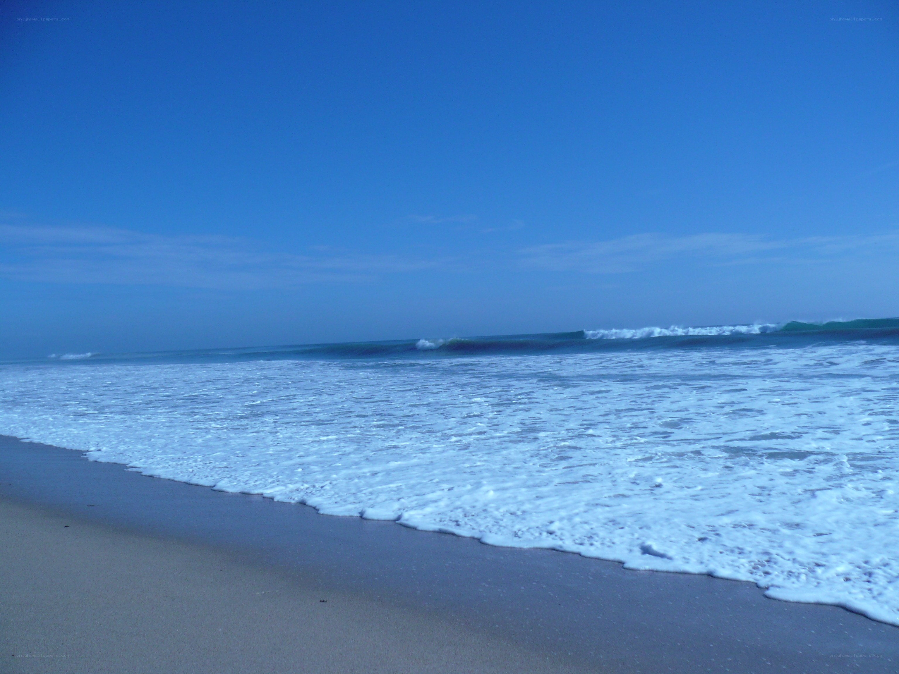 beach waves under blue sky