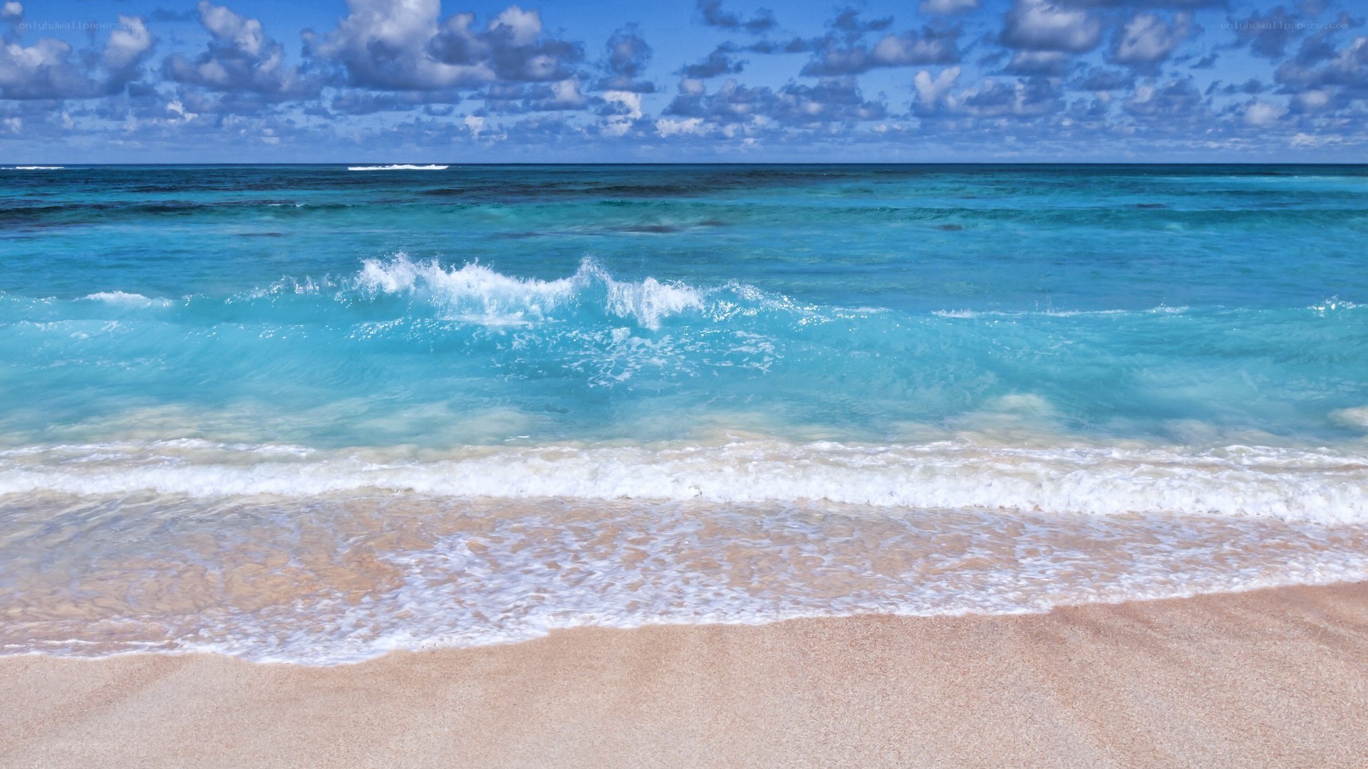 beach waves under cloudy sky