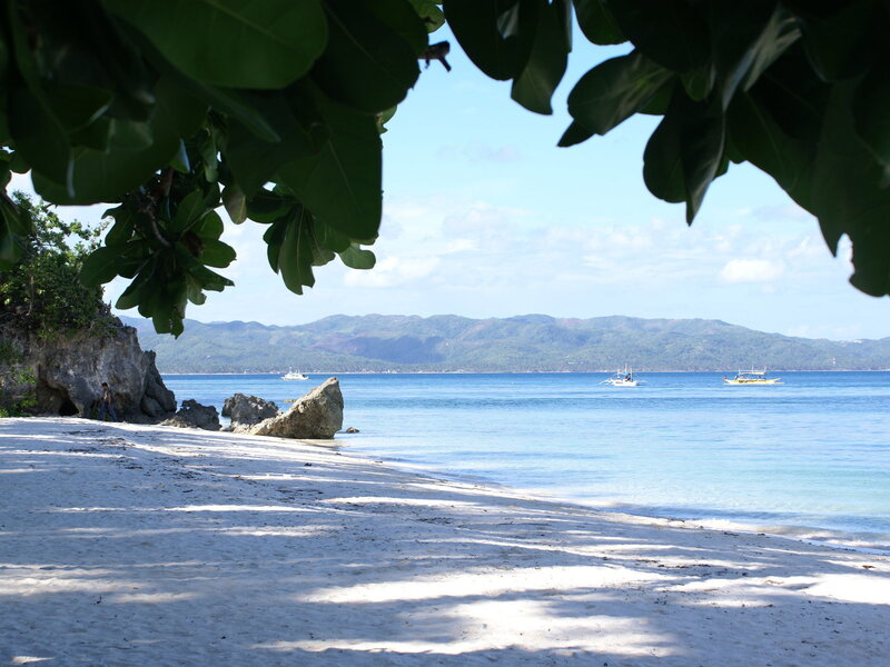 beach with boats and mountains