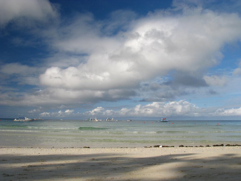 Beach with boats under cloudy sky