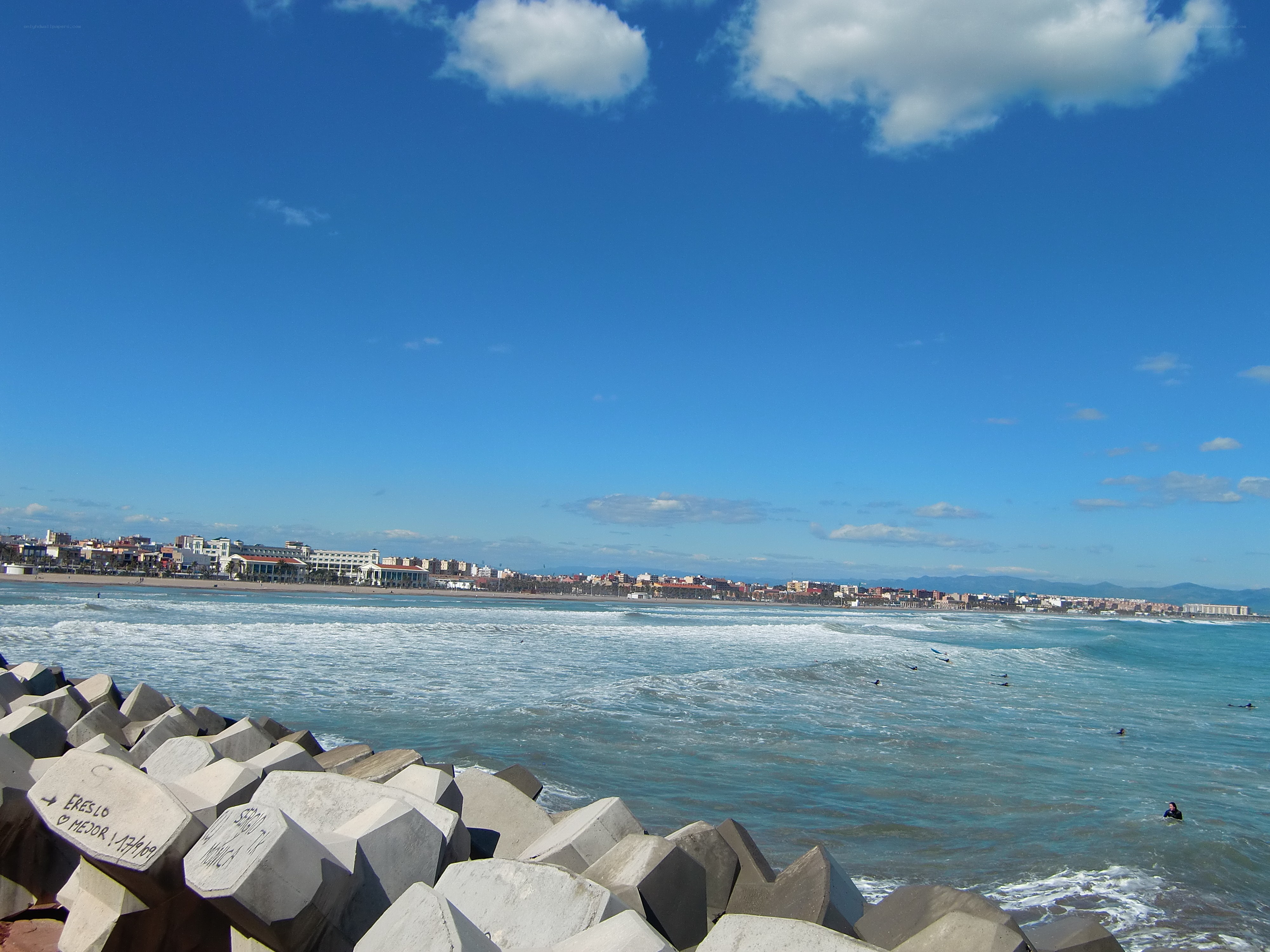 Beach with breakwaters and city view