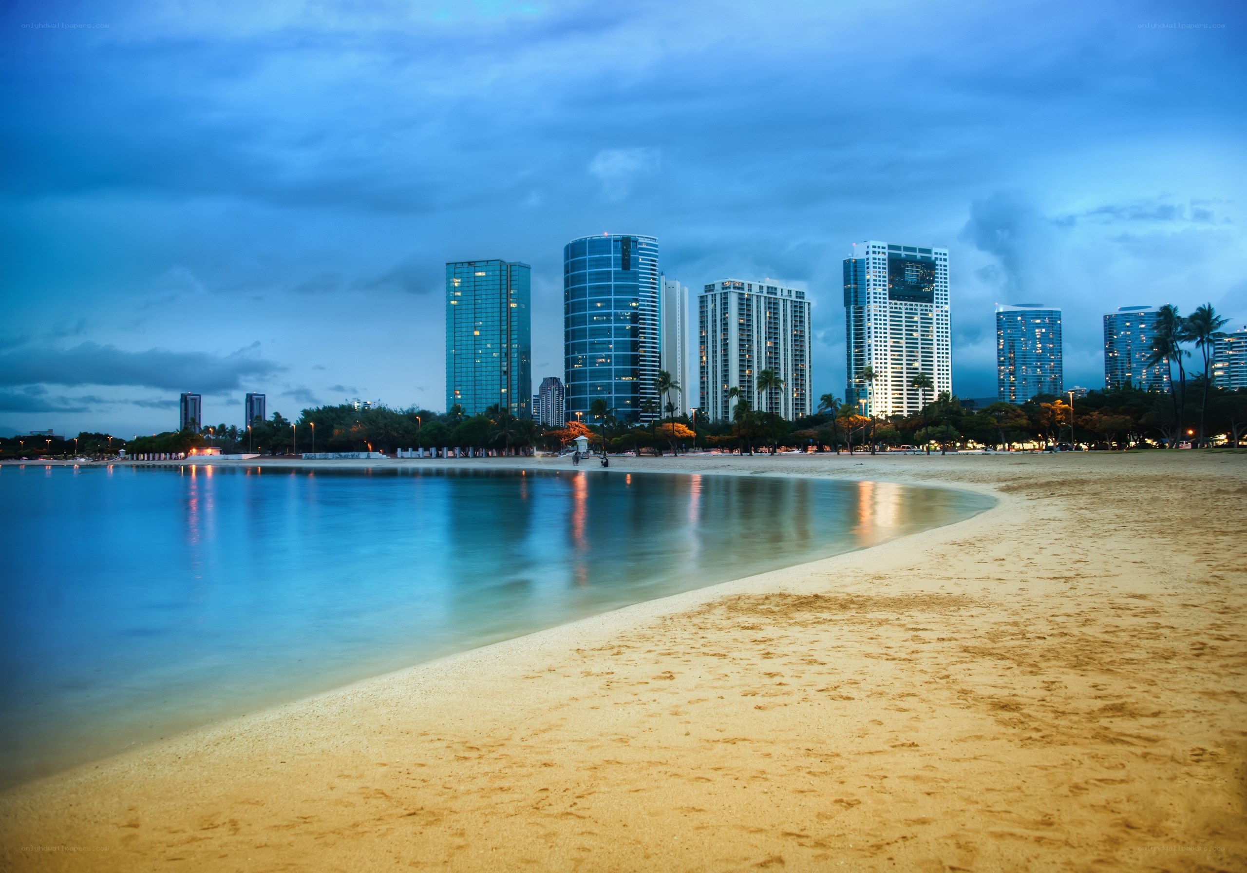beach with city skyline at dusk
