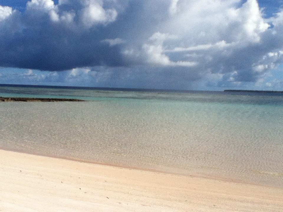 beach with clear water and clouds