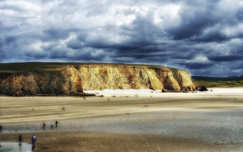 Beach with Cliffs Under Stormy Sky