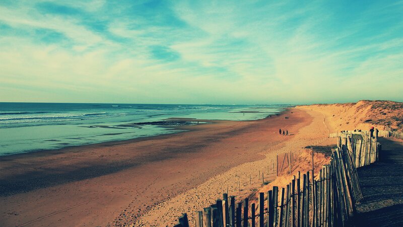 beach with dunes and wooden fence