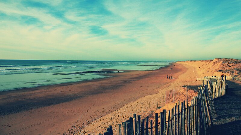 beach with dunes and wooden fence