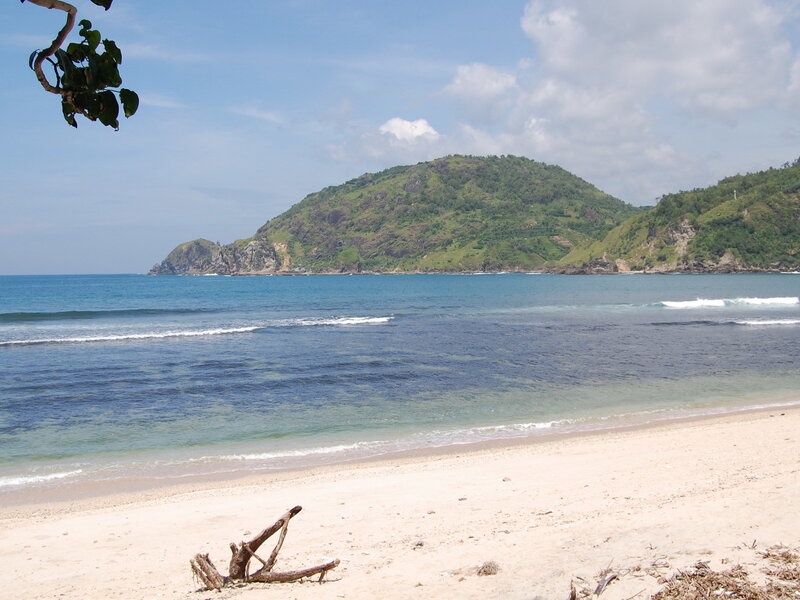 Beach with green hill in background