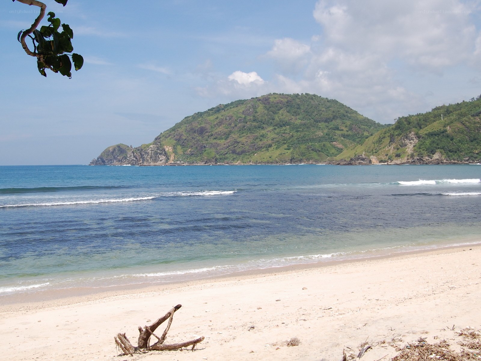Beach with green hill in background
