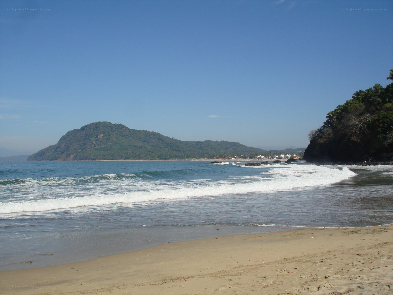 beach with green hill in background