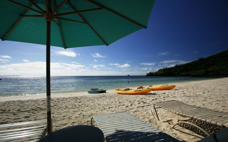 Beach with kayaks and lounge chairs