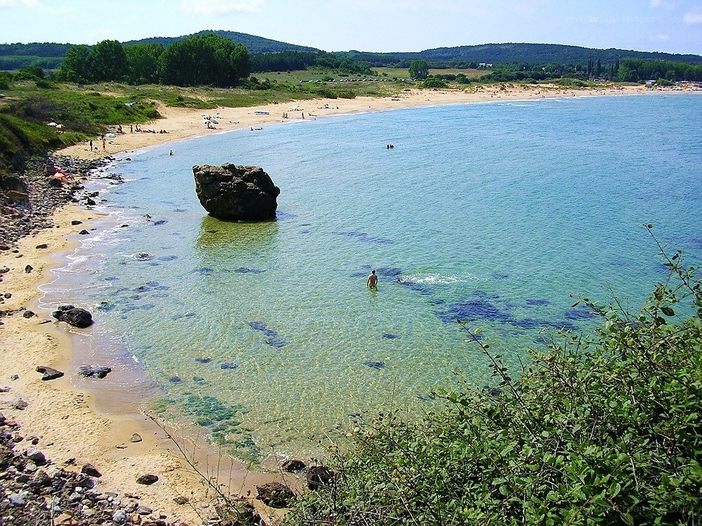 Beach with large rock in water